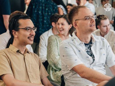 Diverse group of employees laughing during a meeting or presentation.