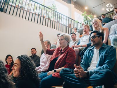 Attentive team listening to a presentation in a casual office setting.