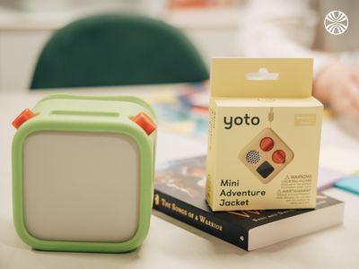 Green Yoto device and accessories displayed on a wooden surface, showcasing Yoto's products..