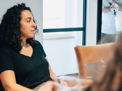 A woman seated and working at her laptop in a meeting room.