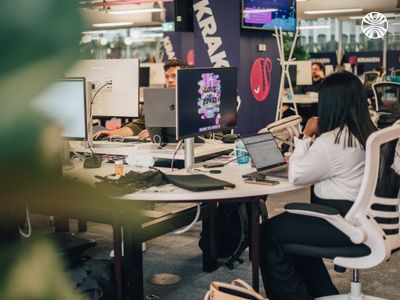 Employee working at desk with personalized workspace featuring decorative neon signs.