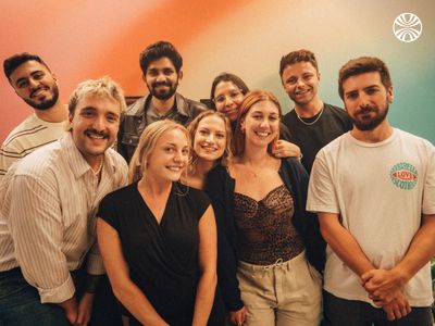 Group of employees posing together in a brightly colored room.