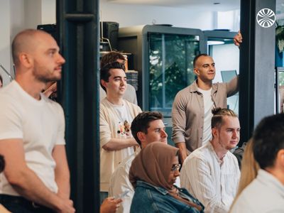 Group of employees gathered in an office space during a meeting or presentation.