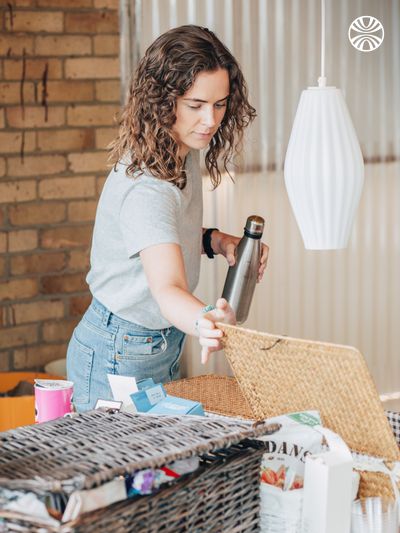 White woman organizing a breakfast basket in an office.