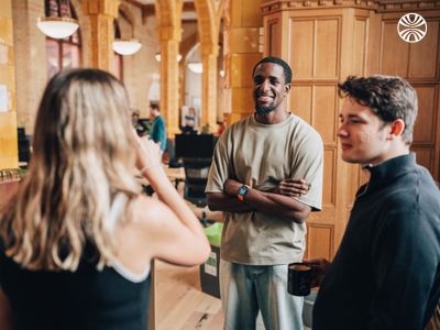 White woman showing notes to two colleagues, including a Black man, in a collaborative setting.