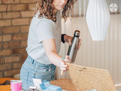 White woman organizing a breakfast basket in an office.