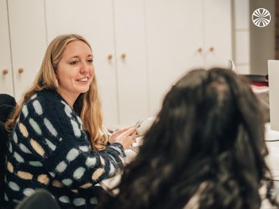 Two team members engaged in animated conversation during a casual office meeting.