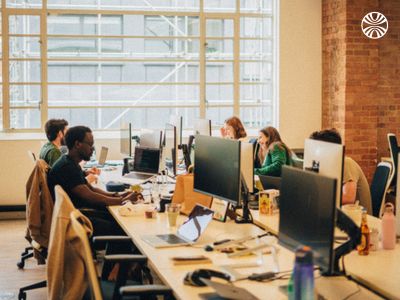 Several coworkers working at desks in an open office.