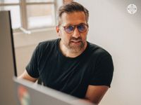 Man with glasses working at a computer.