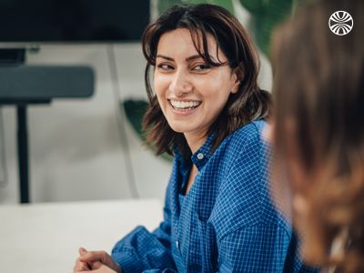 Team member smiling during a casual conversation in an office setting.