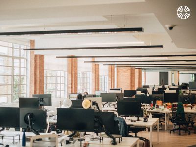 An open office with empty desks and monitors.