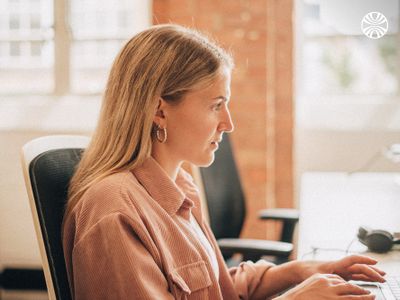 Woman typing on a computer at a desk.