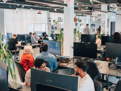 Busy office space with employees focused on their desktop computers.