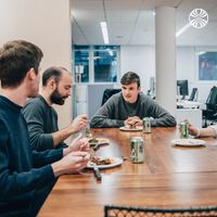 A small group enjoying lunch together at a wooden table.