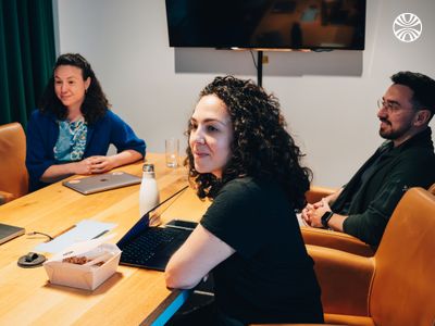 A woman listening attentively to a colleague in a meeting room.