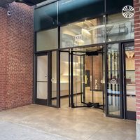 Modern brick building entrance with glass doors and industrial design elements.