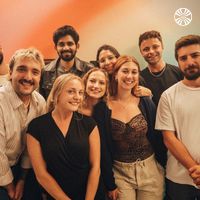 Group of employees posing together in a brightly colored room.